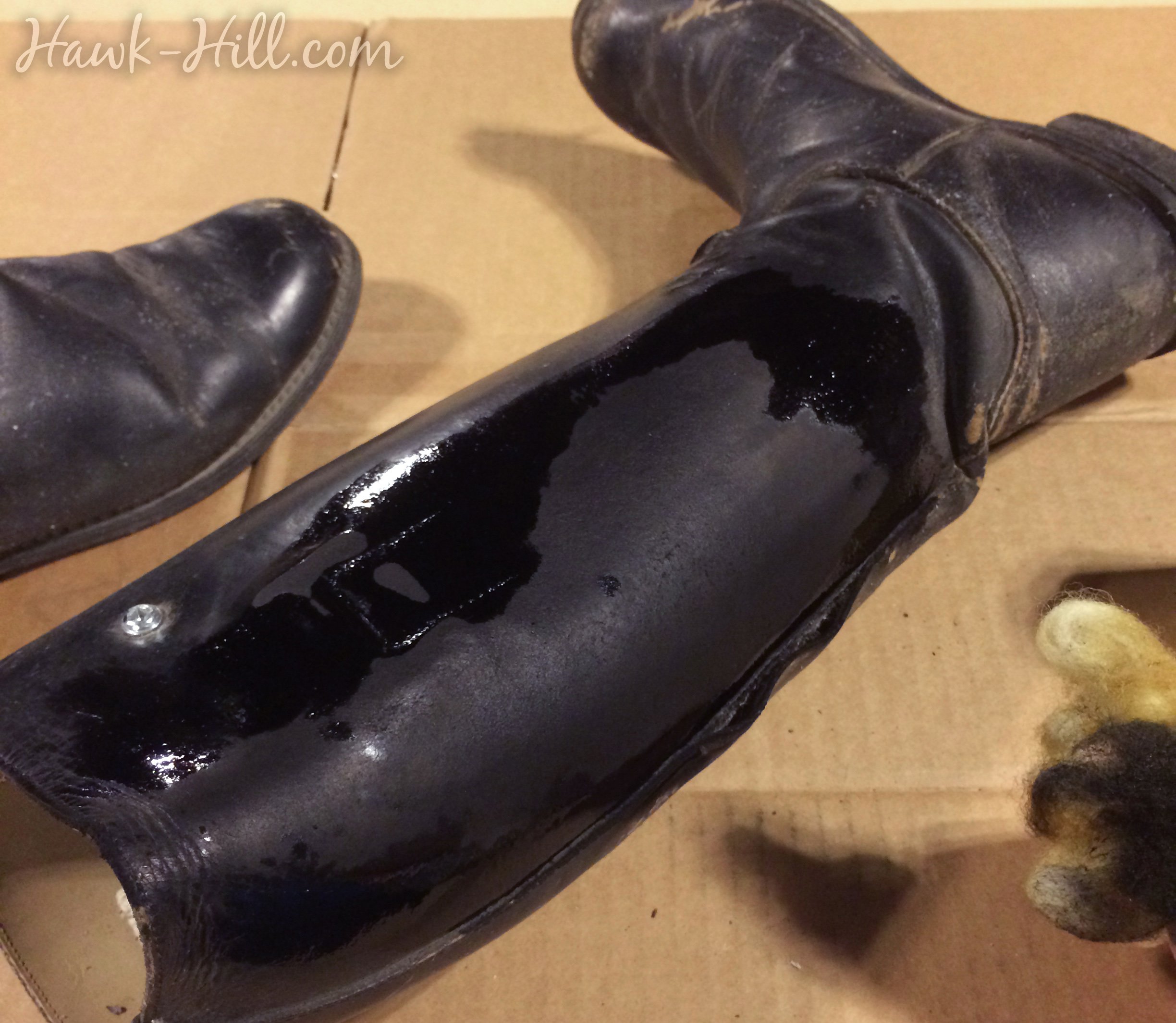 leather dye soaking in to worn patches on an old black riding boot