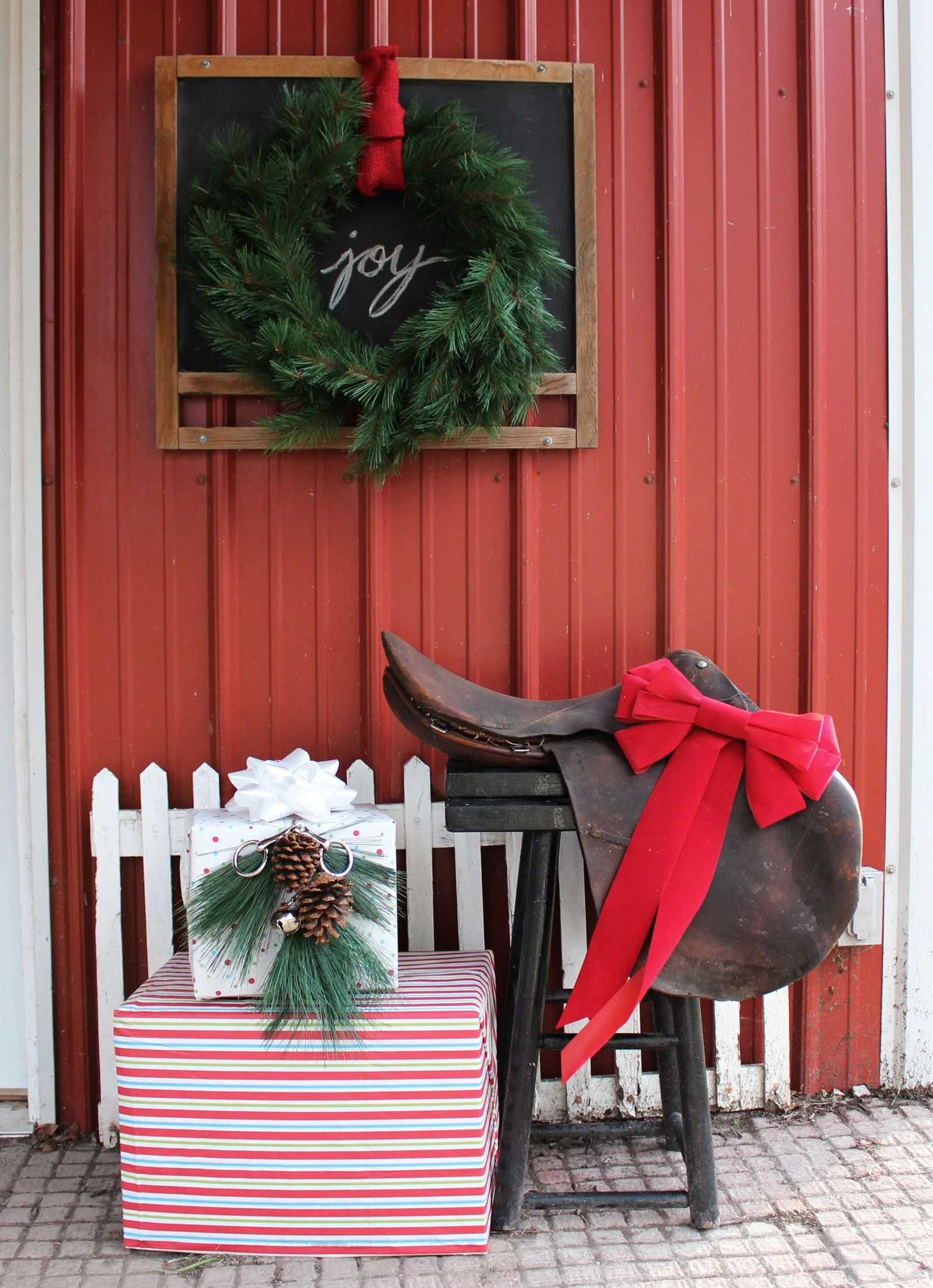 outdoor christmas decorations featuring equestrian english saddle, wrapped gifts, chalkboard, wreaths, silver bells, and snaffle bit