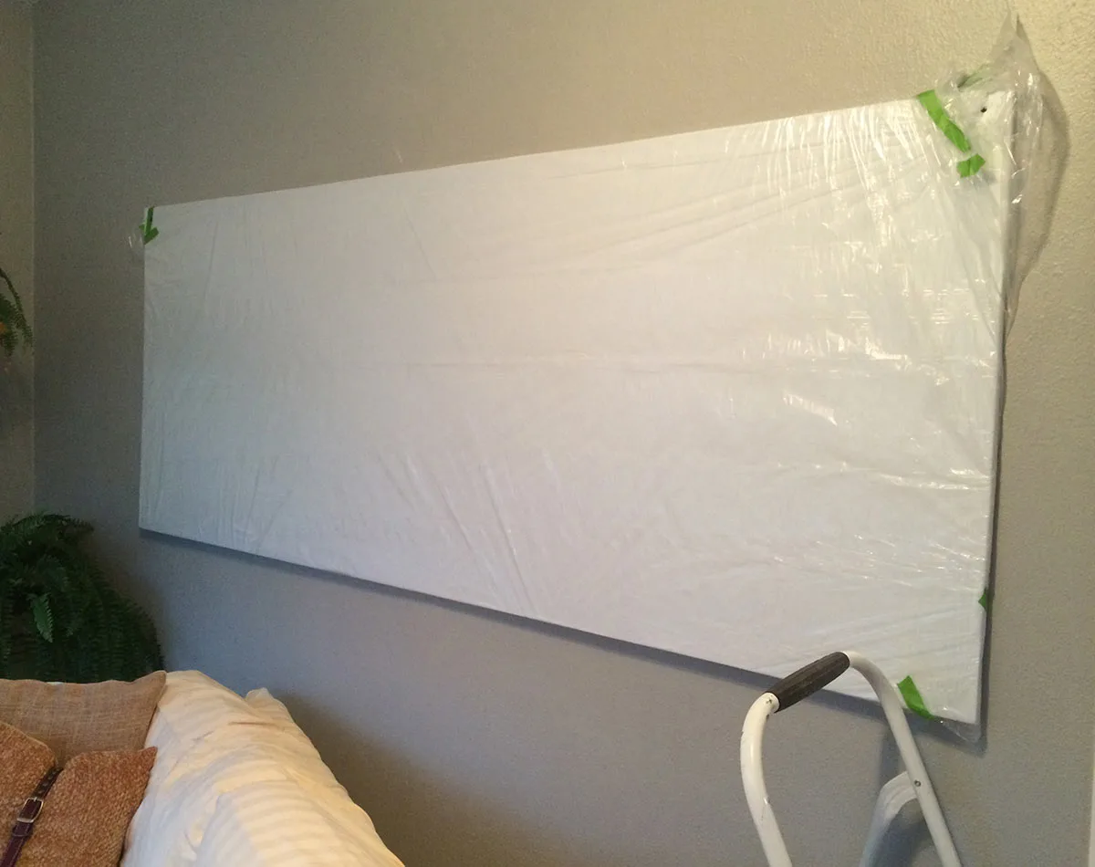 pinboard attached to wall with protective drop cloth plastic