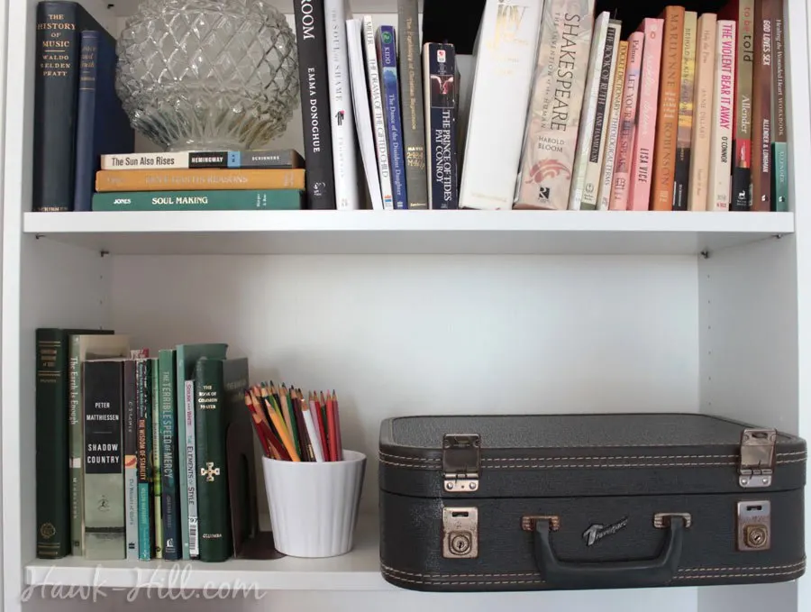 Stationary tucket neatly into a suitcase on a bookshelf