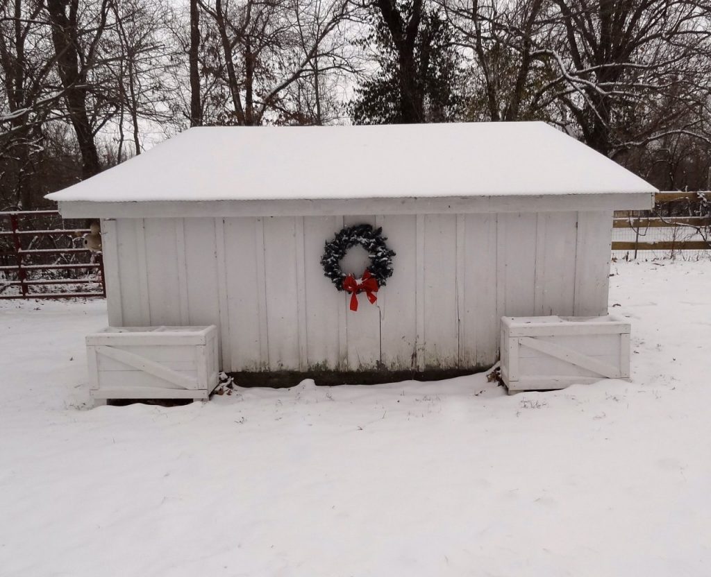 Farm outbuilding in snow with christmas wreath