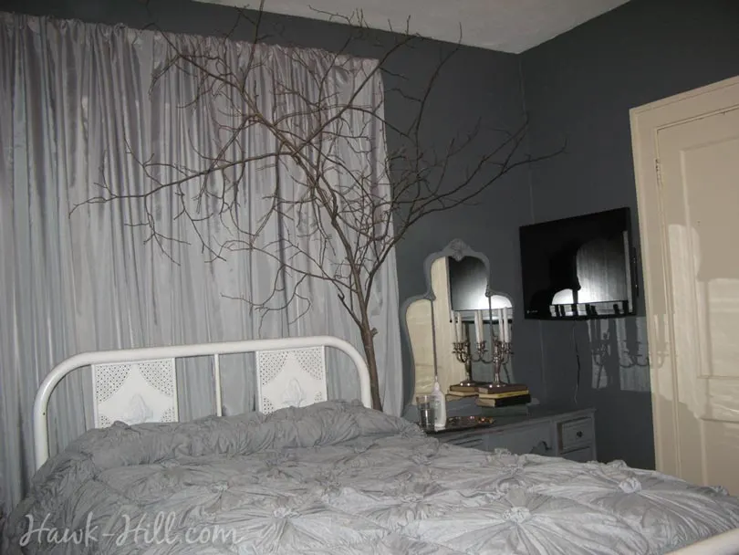 A cozy bedroom with live branches