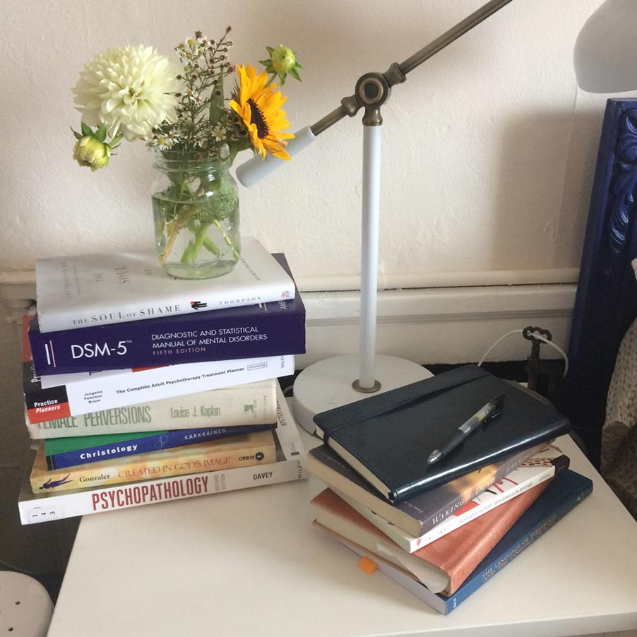 Books on the nightstand with a small bouquet of flowers