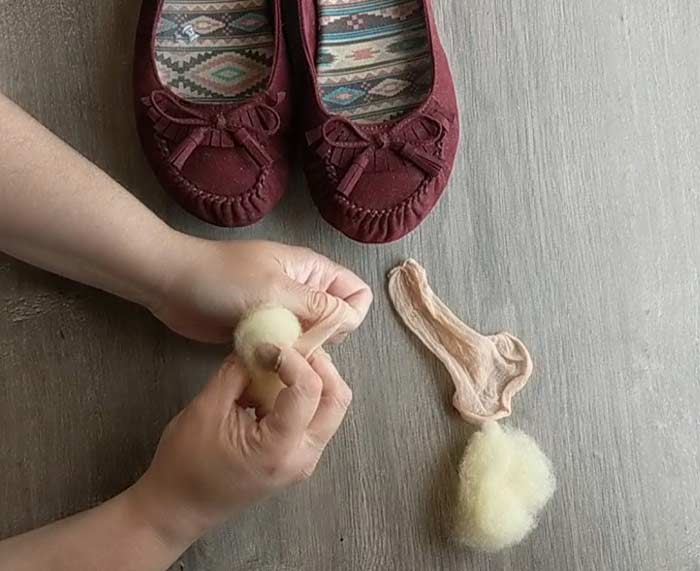 Wrap the soft wool in hosiery- this will keep the fibers from migrating around your shoe and help the wool conform to your foot