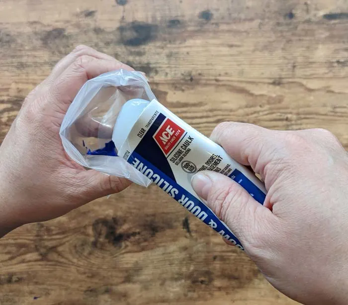 Squeezing silicone caulk into a bag for easy mixing
