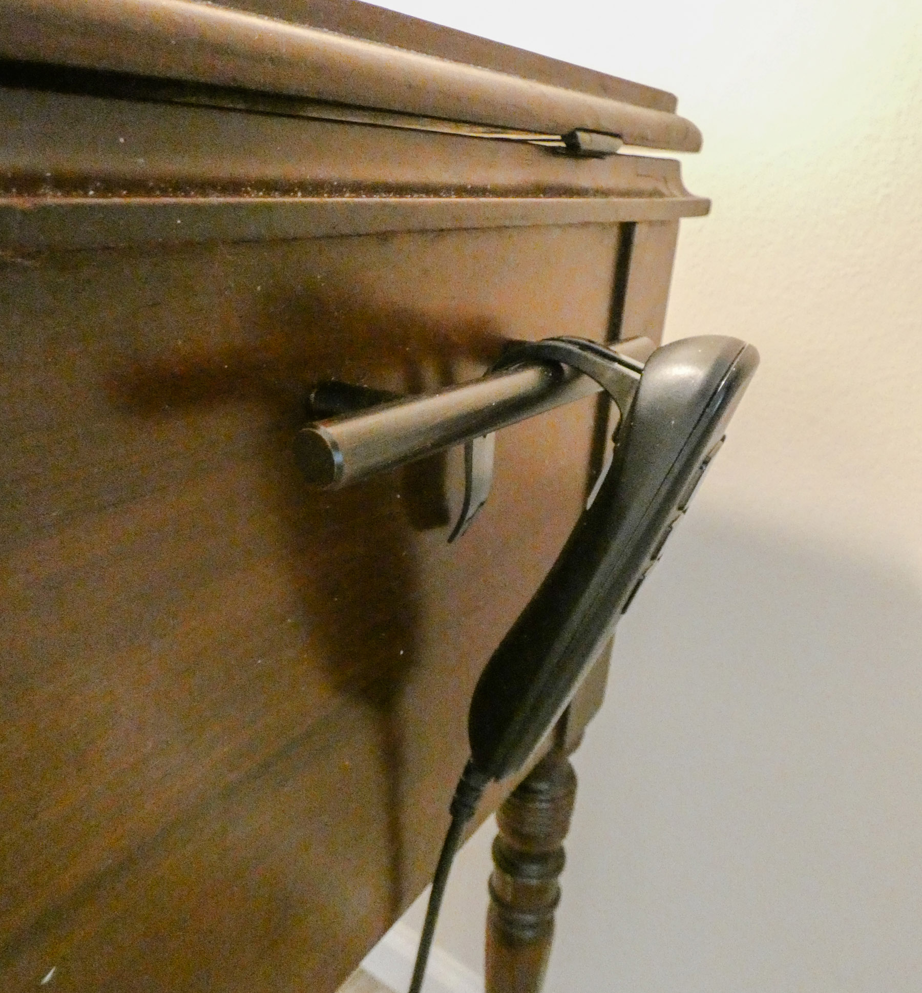 An adjustable base bed remote resting and a holder attached to a night stand.