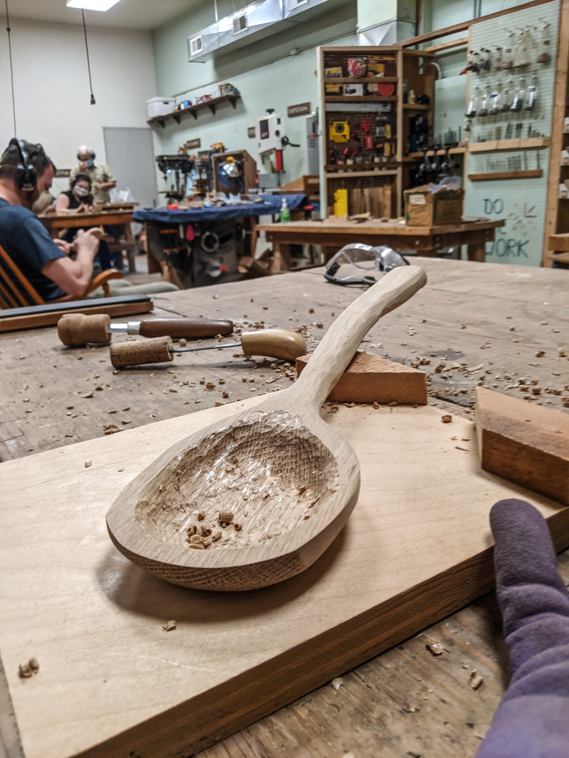 A handmade wooden spoon partially carved.