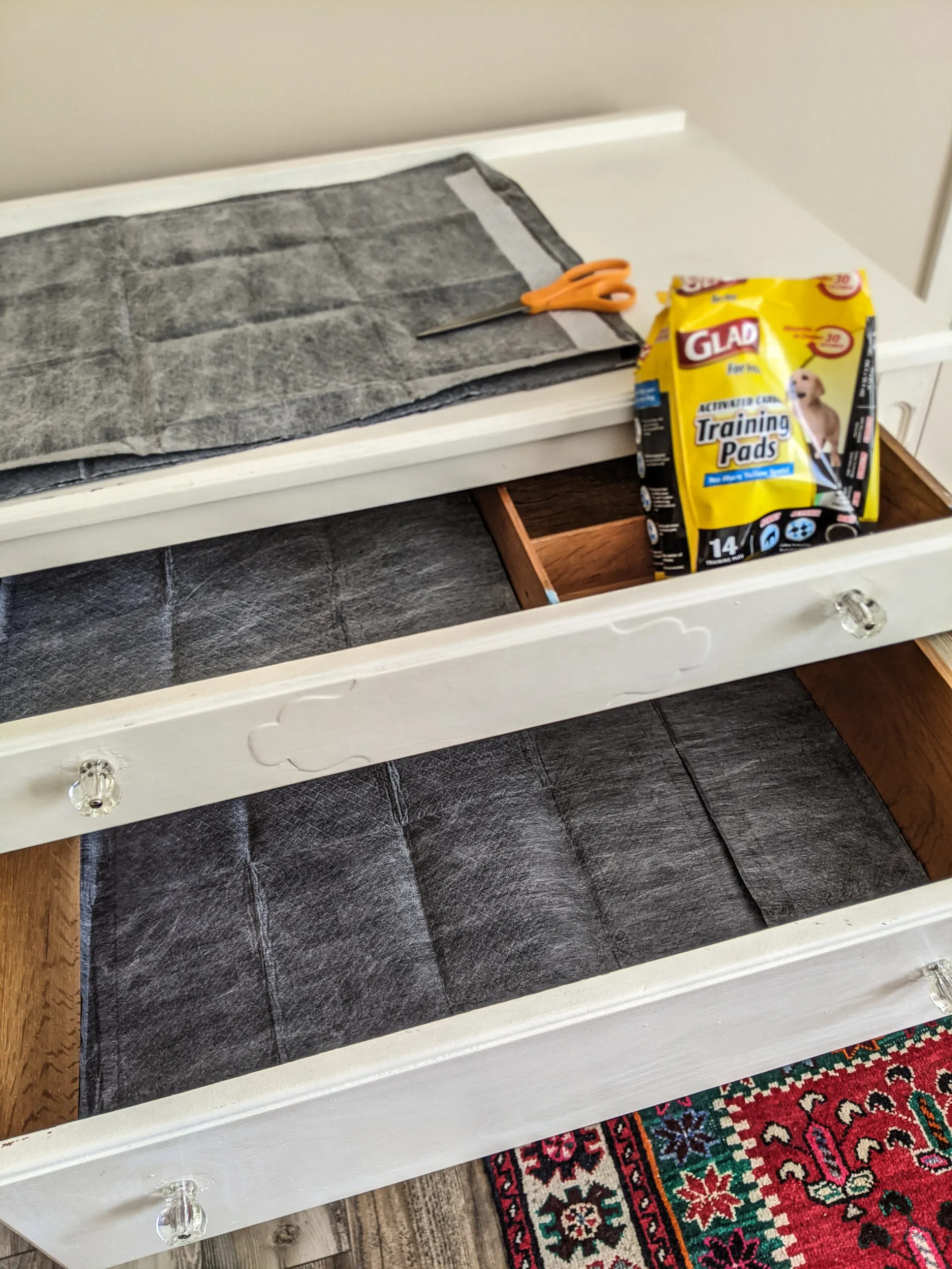 Wood dresser drawers lined with activated charcoal puppy pads.