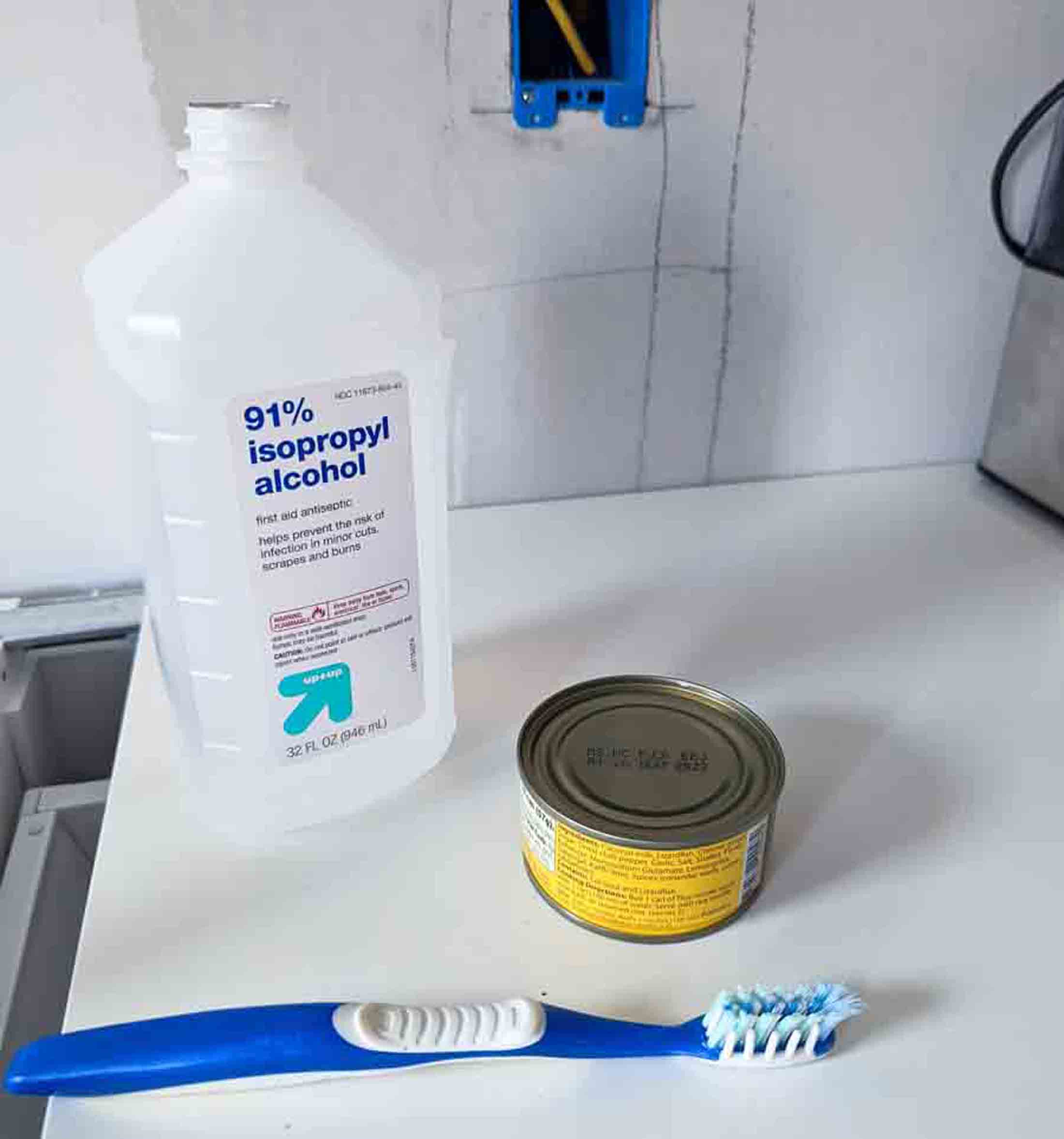 Items needed to clean dirty light switches and outlets: rubbing alcohol, toothbrush, shallow dish.