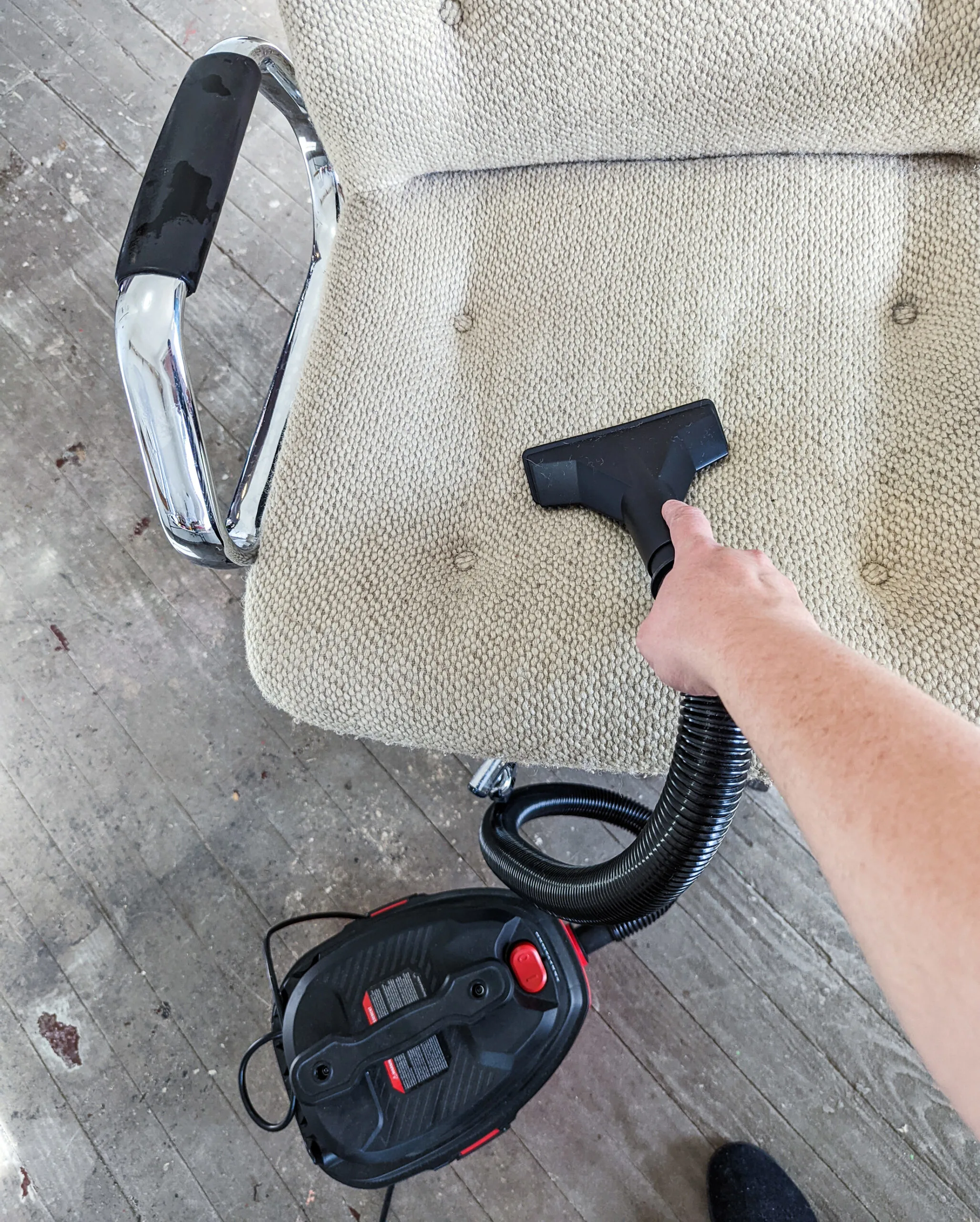 Using a vacuum to remove the breeze from the seat of a vintage MCM office chair