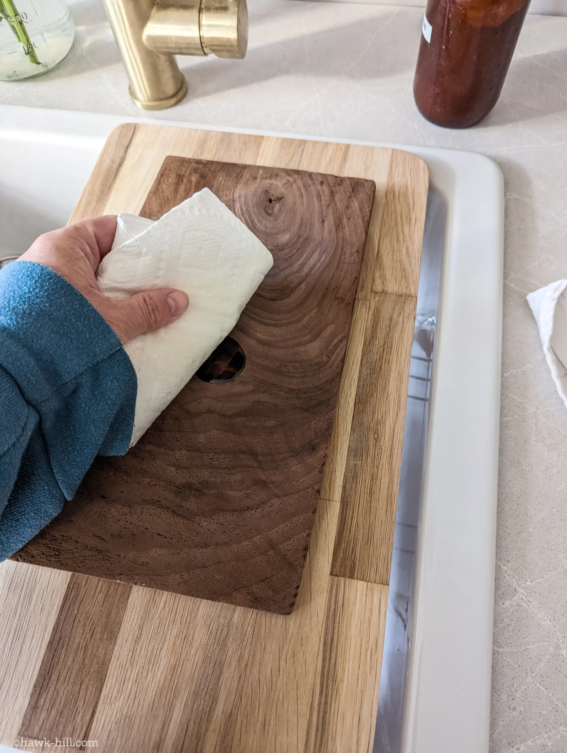 Wiping grape seed oil into the surface of a rustic homemade cheese board.