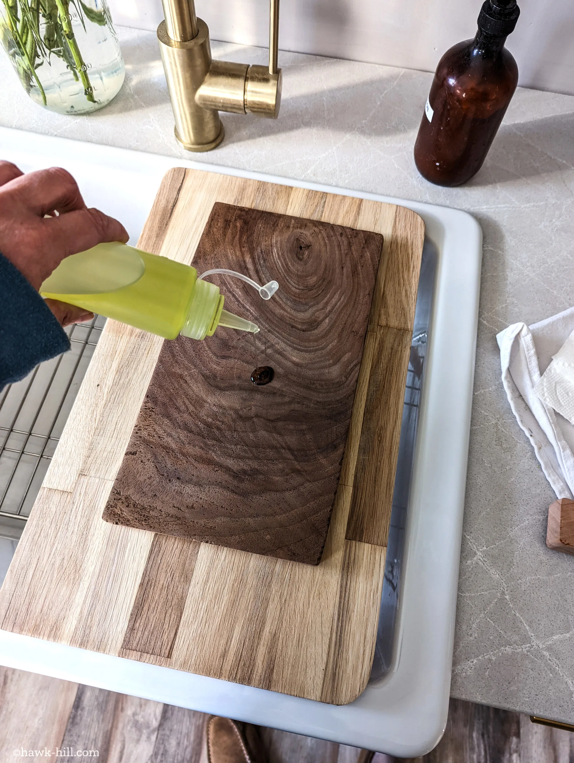 Dripping grape seed oil onto a handmade walnut cheese board.