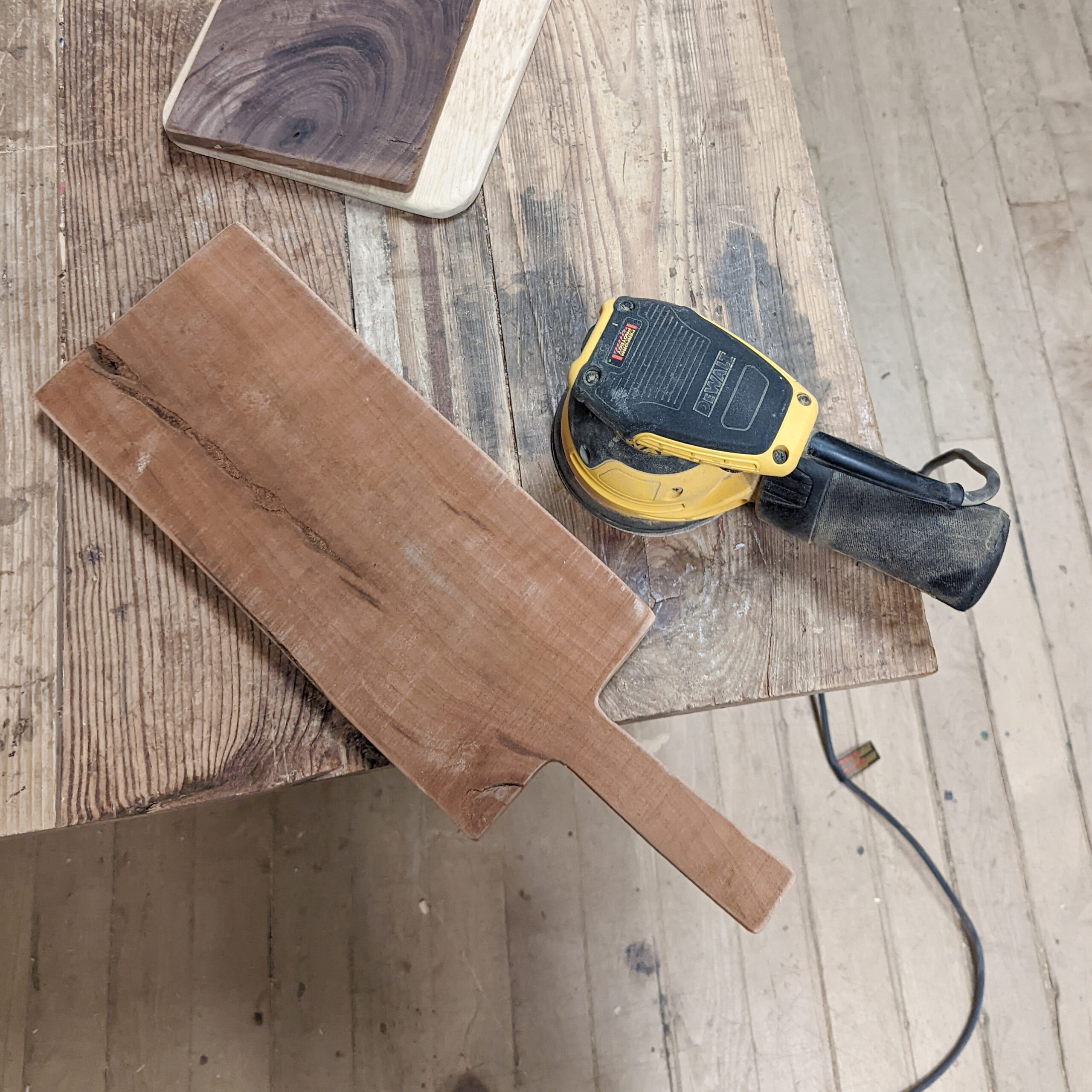 A palm sander helps soften edges of my DIY rustic cutting boards.