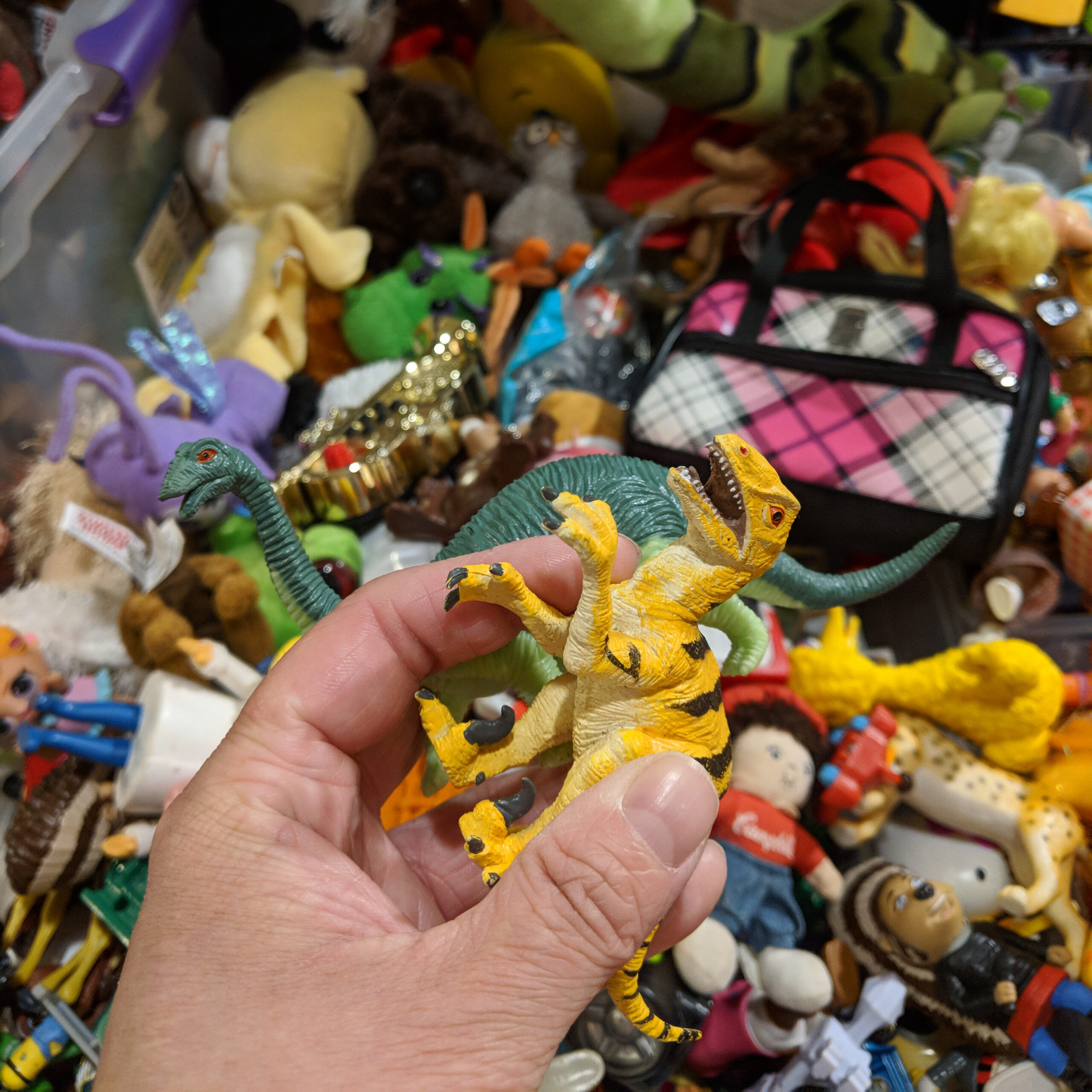 sorting through toys in a thrift store bin
