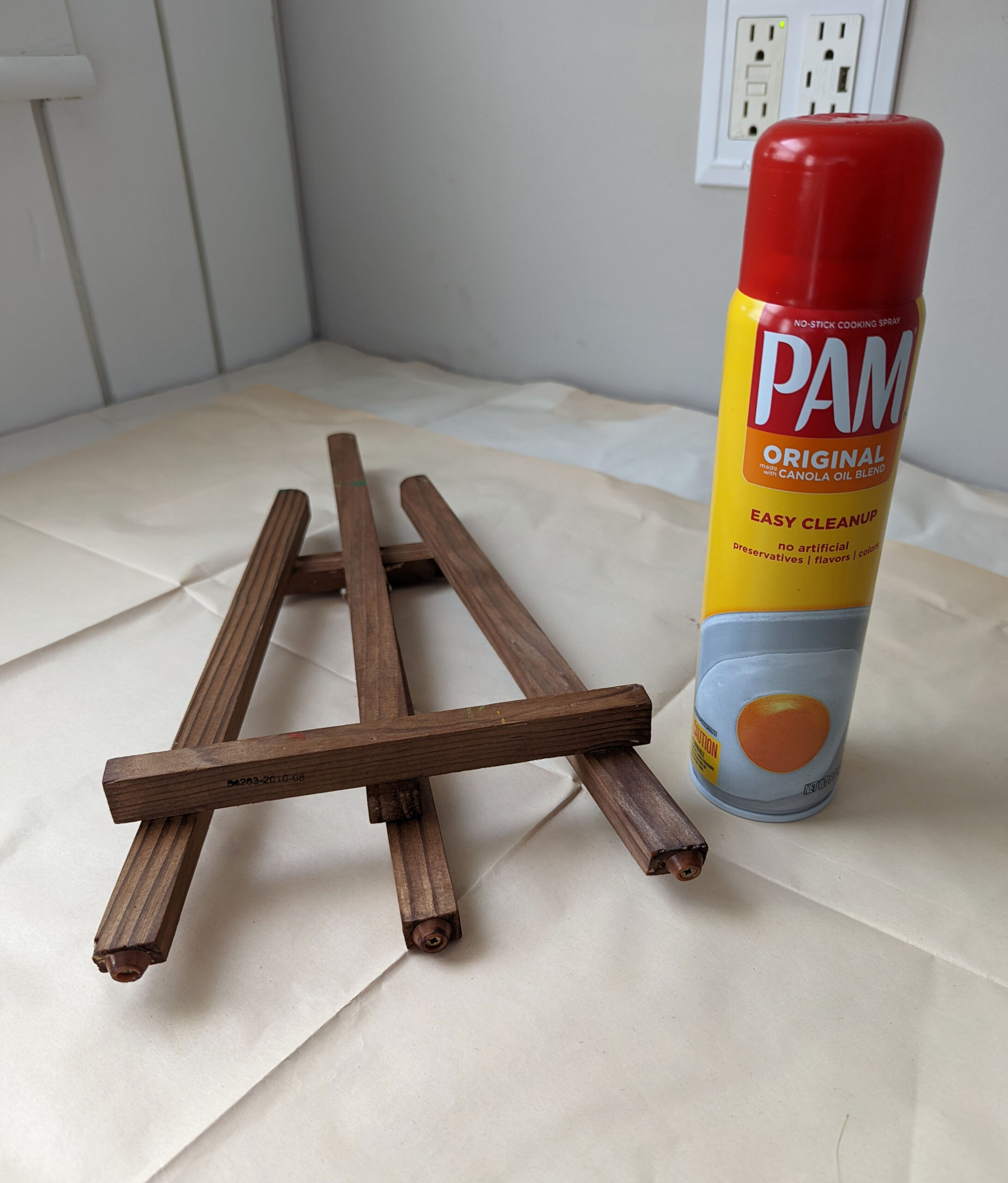 A dollar store wood easel being stained with vinegar based wood stain.
