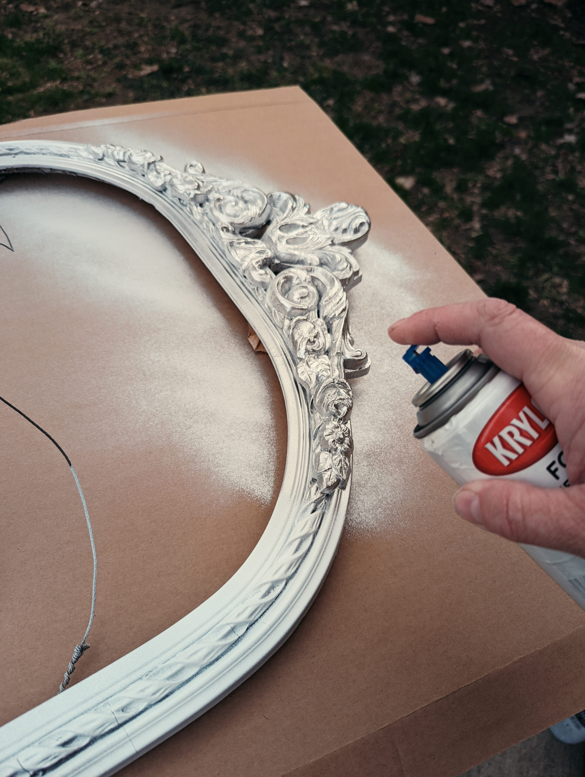 A frame being painted with an antique silver finish.